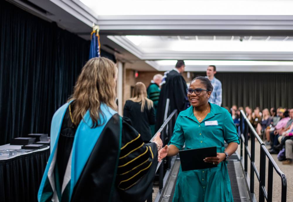 Student shaking hand with faculty 8